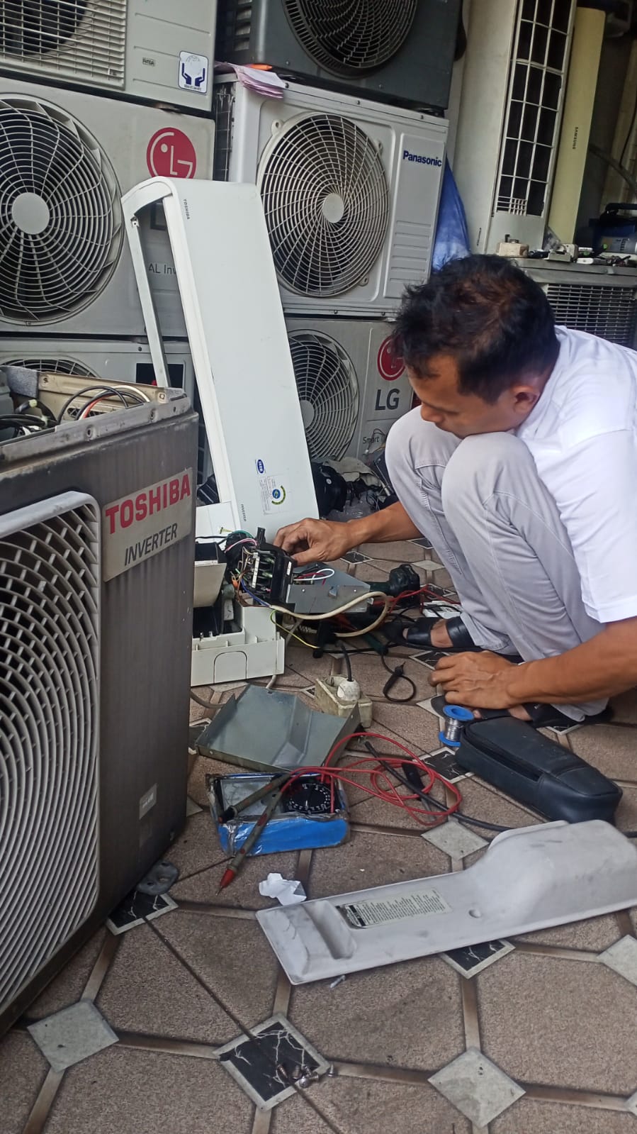 Teknisi AC profesional sedang bekerja